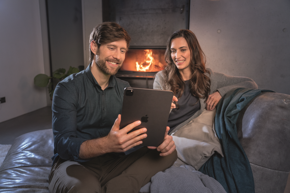 couple on couch with tablet and fire in the background