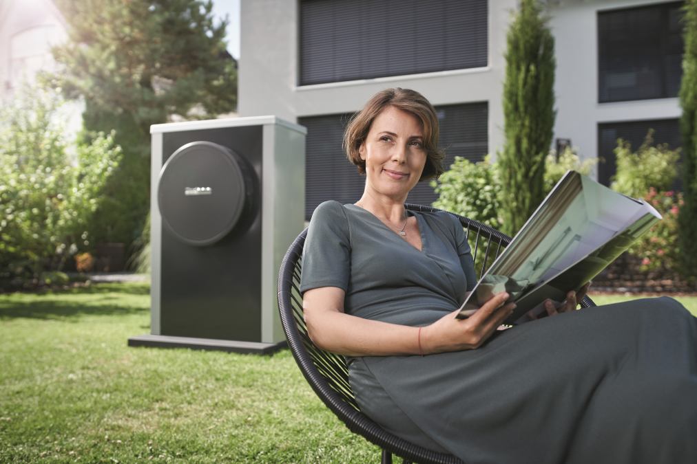 woman sitting in a chair with heat pump in garden