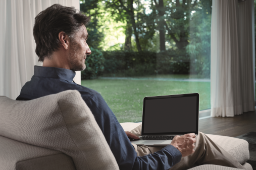 man with laptop looking at the garden