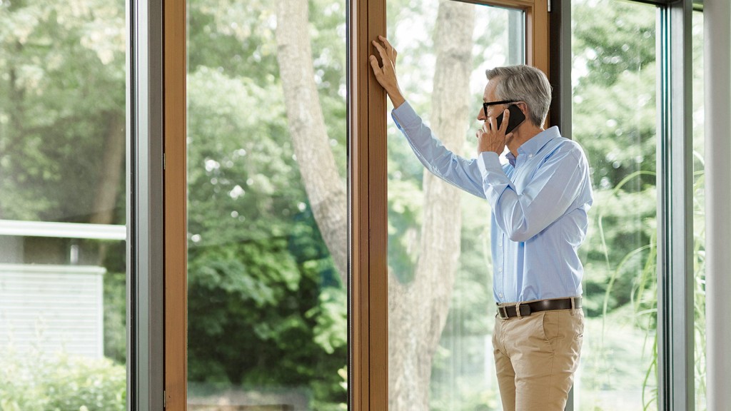 Klimatizácia inštalovaná nad posteľou v spálni, vonkajšia jednotka viditeľná v záhrade za terasovými oknami